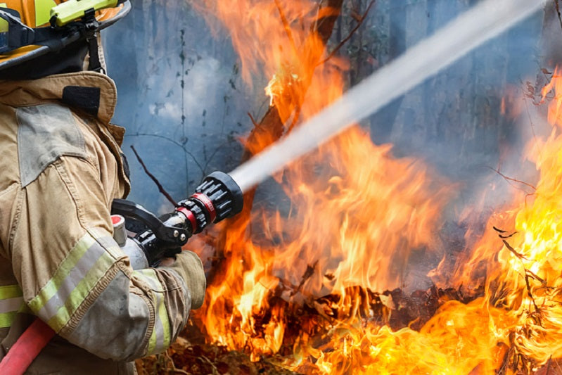 firefighters spray water to wildfire