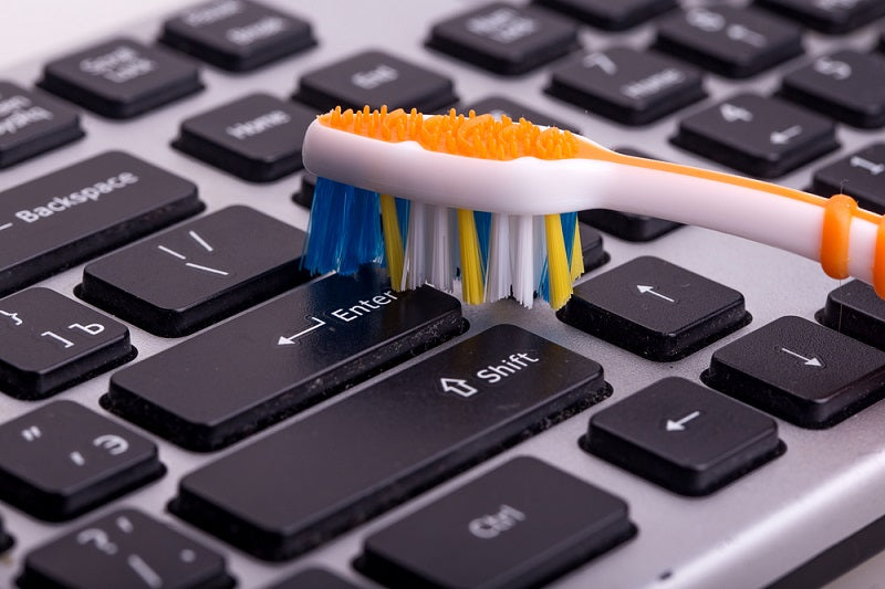 keyboard cleaning with old toothbrush