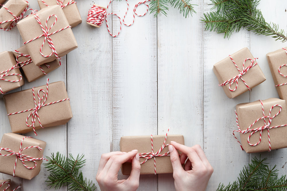 Tying a bow on gifts wrapped in recycled paper