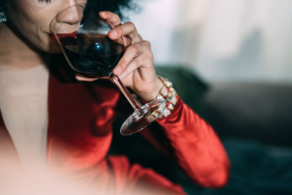 Mujer de vestido tomando vino tinto