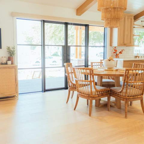 Home interior with steel door, and round wicker dining chairs and table  