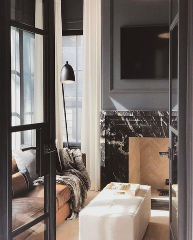 A room interior with black marbled accent walls and brown furnishings.