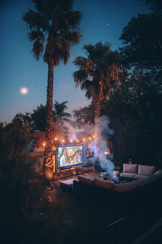 stunning outdoor movie theater setup with fairy lights and comfortable sectionals