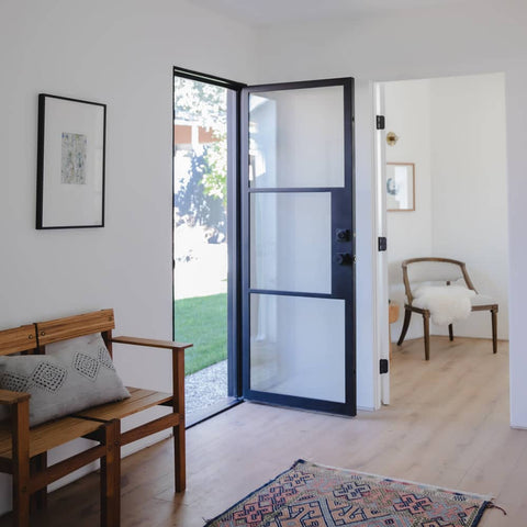 Single entryway door made from iron with simple horizontal bars and a full panel of glass