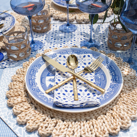 Close up of tablescape with Estelle Colored Glass x HONEY + HANK Napkin on blue and white Spode plate