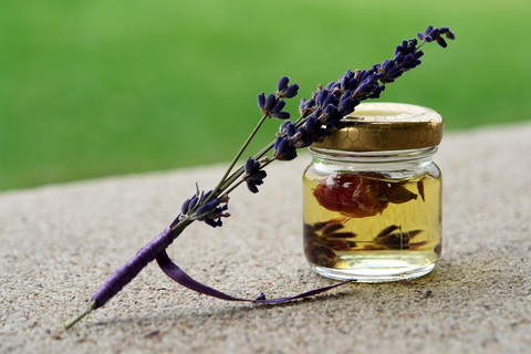 ALT Text: Lavender plant on top of an essential oil