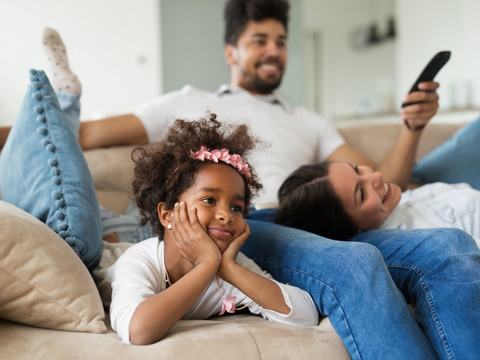 A family on the couch watching TV