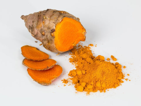 Sliced fresh turmeric with ground turmeric