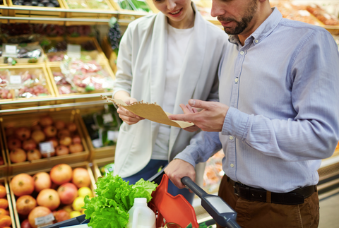 couple looking at shopping list in the produce section