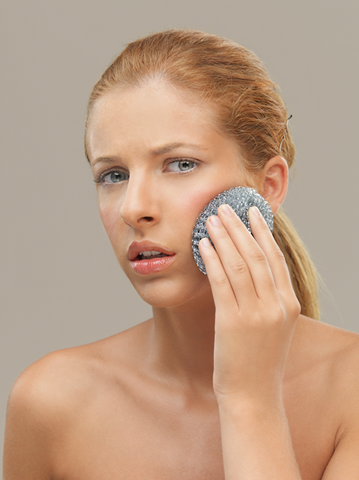 woman using metal sponge on her face