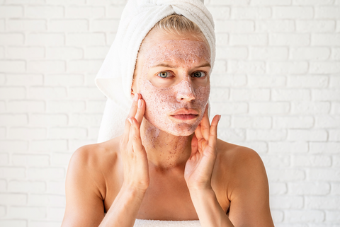 woman concerned while putting face scrub