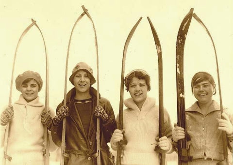 Girls with old wood skis.