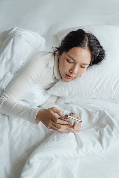 woman on her phone in bed