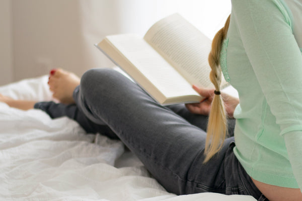 woman reading a book in bed