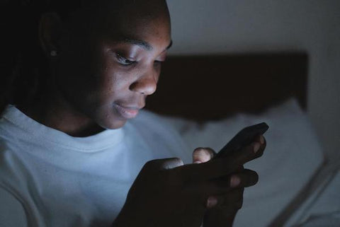 woman on her phone in bed at night