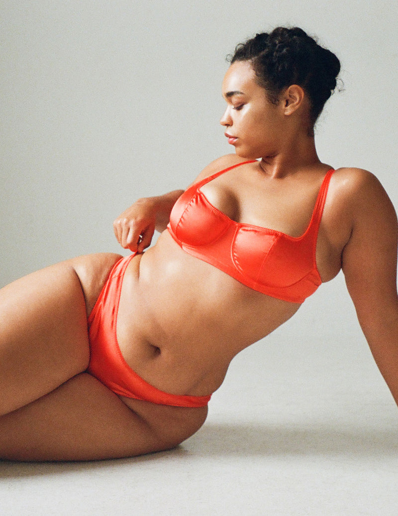 A model wearing the Gita Underwire Bra in Bright orange silk