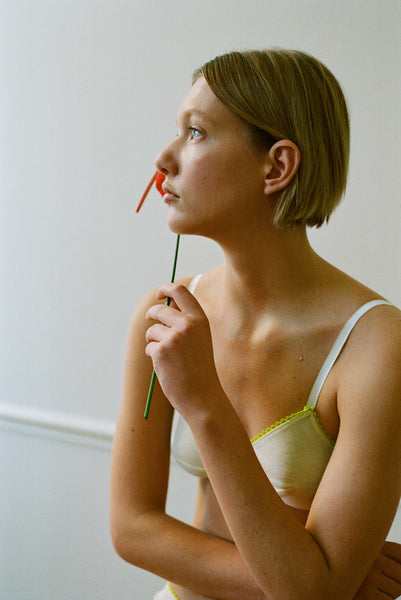 The Antonia Bralette in light yellow worn on a woman.