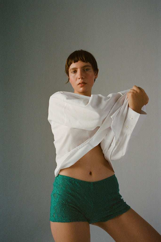 A model wearing the Guinevere Shorts in Green.