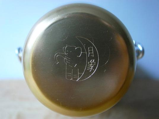 Gold circle with a stenciled elephant.