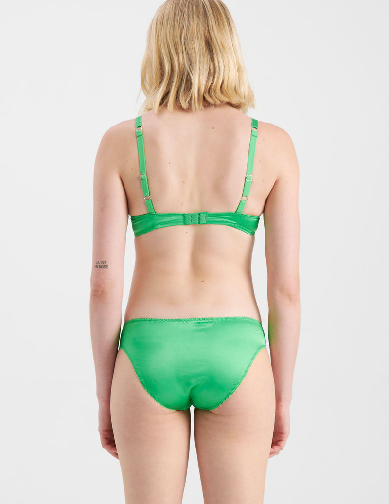 back view of woman wearing green silk panties with a matching bra