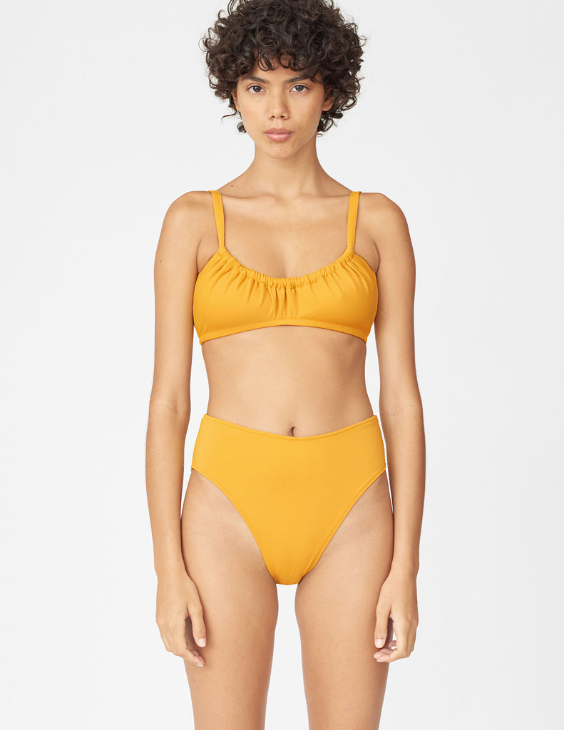 Front view of woman wearing a yellow bikini top with matching bikini bottom