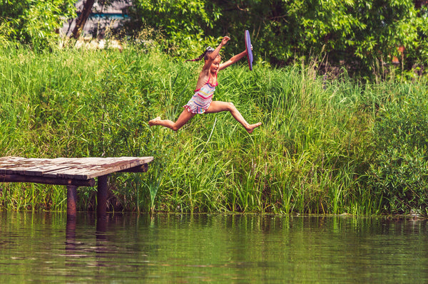 a child jumping into lake