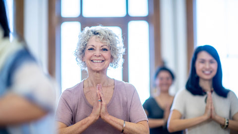 Old white woman and young asian woman doing yoga