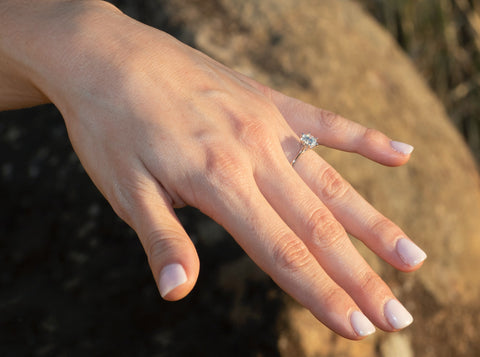 Mano de mujer con anillo de diamante en mano extendida