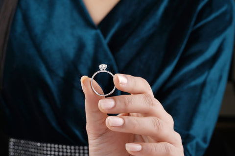 Mano de mujer mostrando anillo solitario