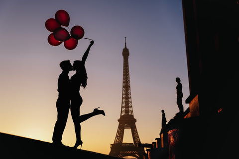 Pareja sosteniendo varios globos con la Torre Eiffel de fondo