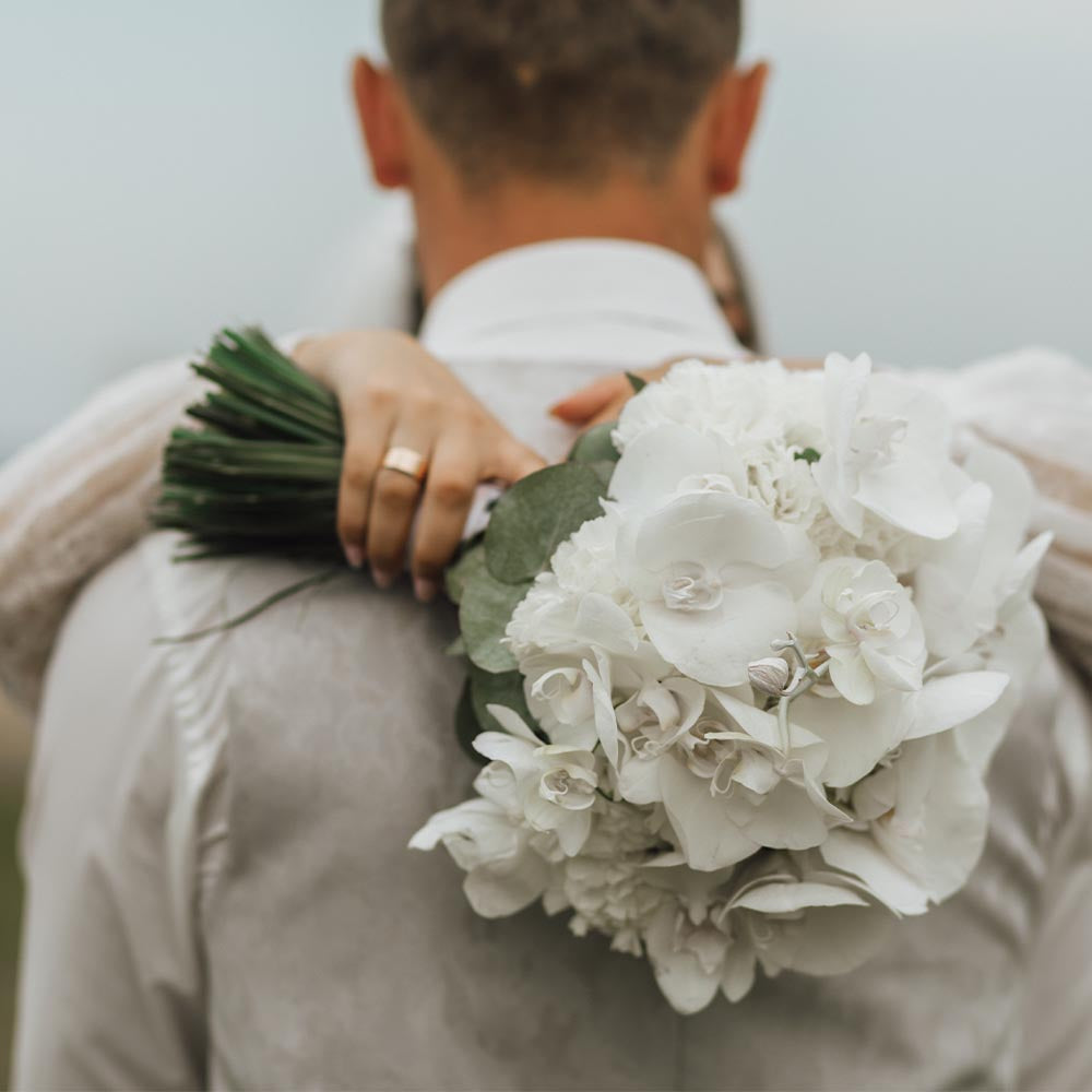 Happy Wedding Couple posing for photos with white bouquet