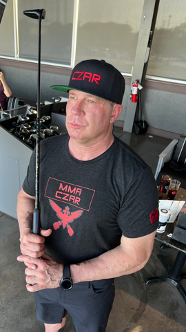 Czar Michael is wearing an MMA Czar Shirt and Embroidered Czar Hat for Czar Clothing at Top Golf in The Colony, Texas.