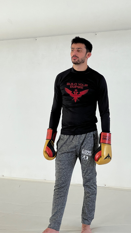 Black and Red Build Your Empire Long Sleeve Rash Guard, Gray Joggers with white Czar Boxing embroidery and black accents, Gold Czar Clothing Boxing Gloves and MMA Omar Ramahi for Czar Clothing