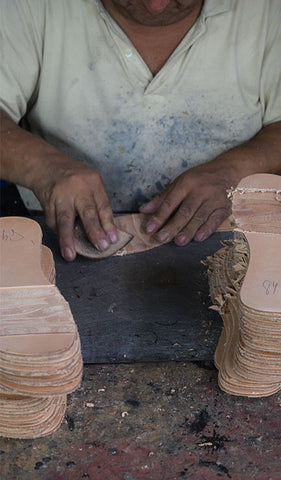 fortress of inca factory tour - person working on leather insoles for shoes