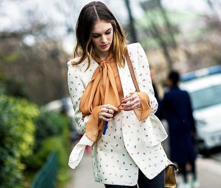 Girl walking in printed blazer and orange bow blouse