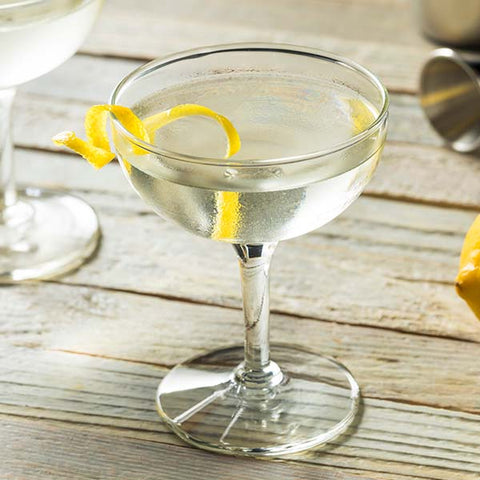 Imperial Cocktail auf Holztisch mit Zitronenschale, Gin und Dry Vermouth