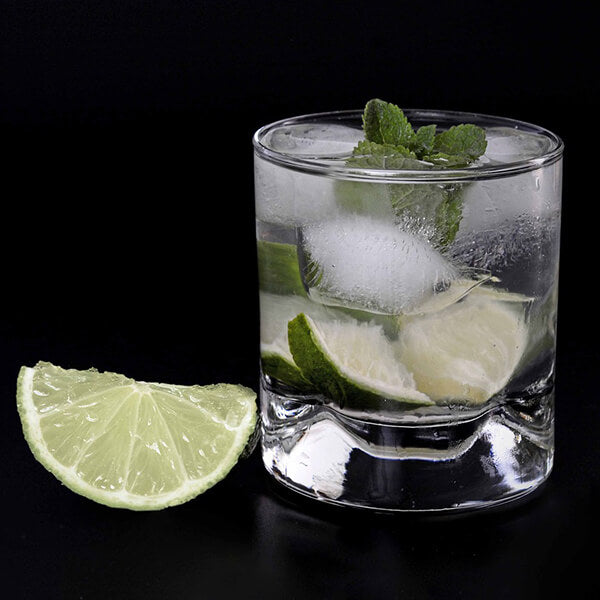 caipiroska cocktail mit Limette auf schwarzem Hintergrund