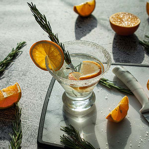 Elderflower Collins Gin Cocktail Orange auf hellem Hintegrund