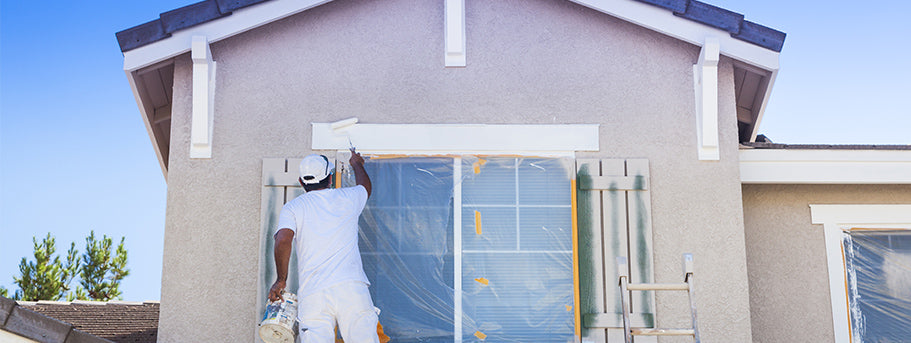 man painting exterior of house