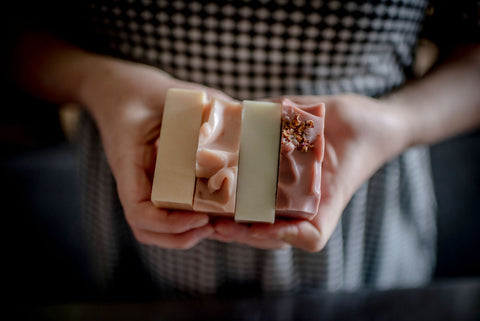 hands holding four natural artisan bar soaps