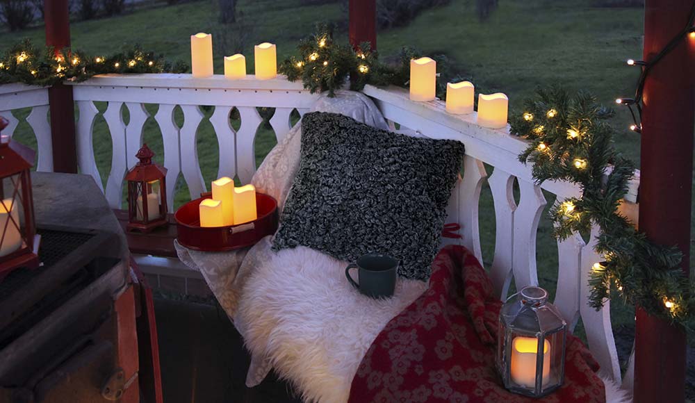 LED gyertyákkal feldíszített karácsonyra dekorált terasz.