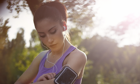 woman in running gear fixing the phone-band on her arm