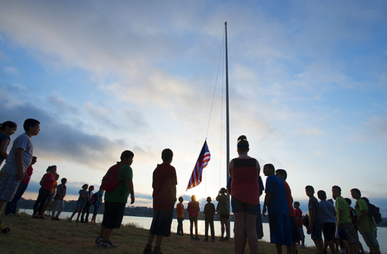 Raising the flag is tradition at summer camp.