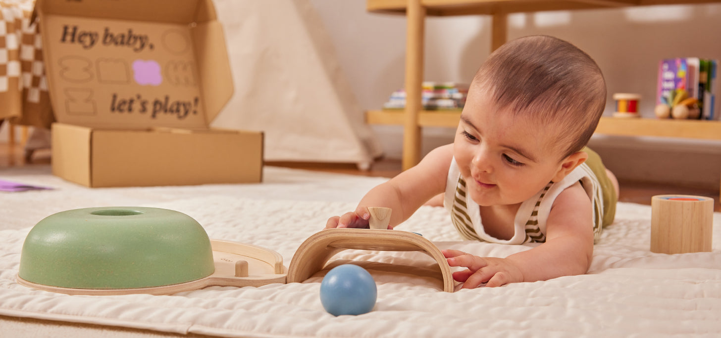 Image of baby playing with wooden toys on a soft play mat