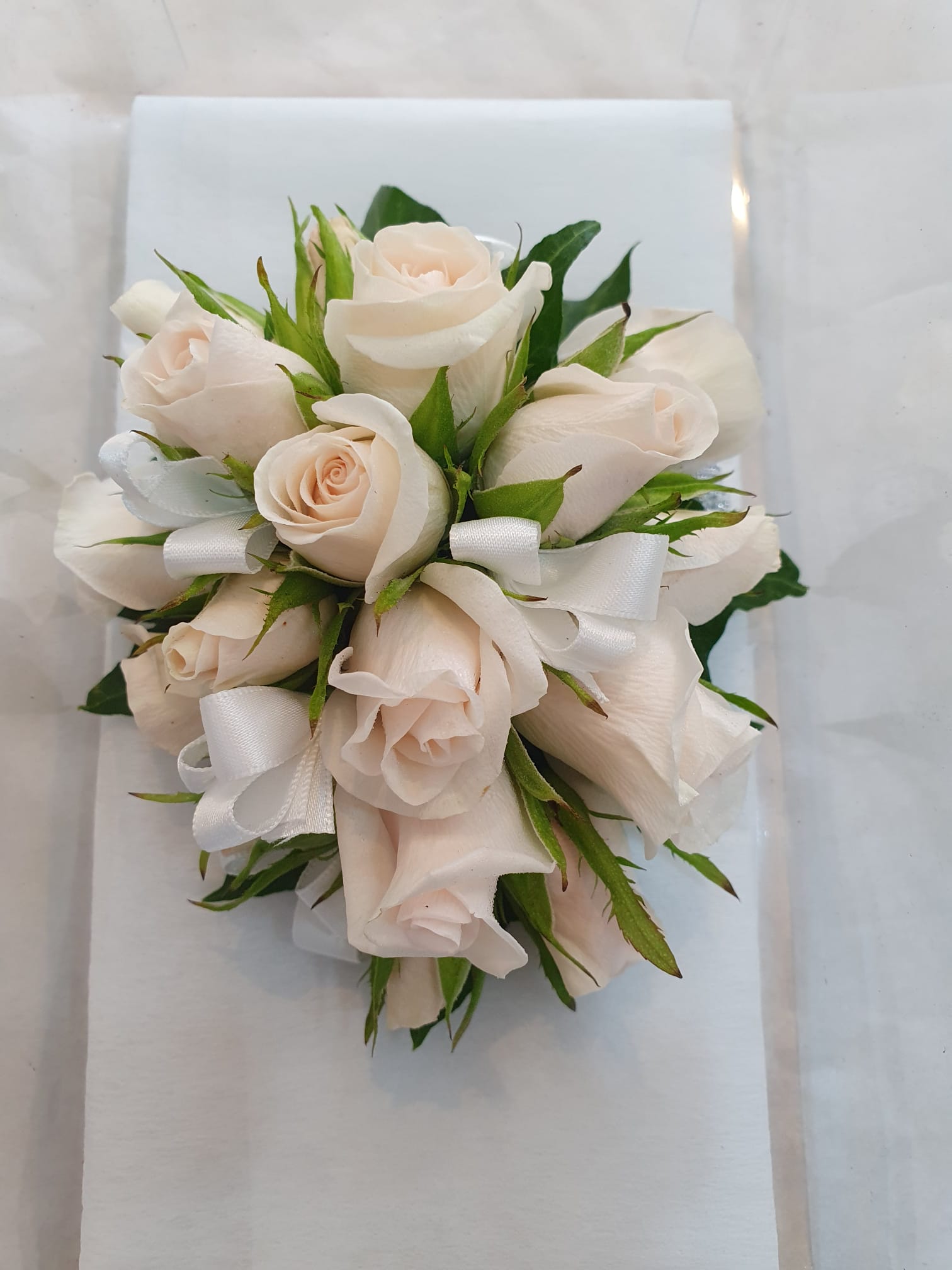 formal corsage of pink baby roses and white ribbon 