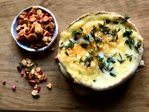 A cranachan crumble mix is placed in a bowl beside a baked Winslade cheese.