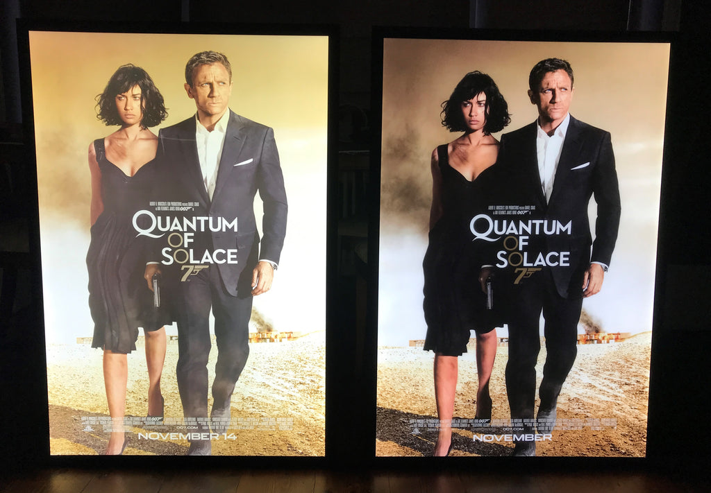 A single sided and double sided movie poster side by side in back-lit movie poster frames