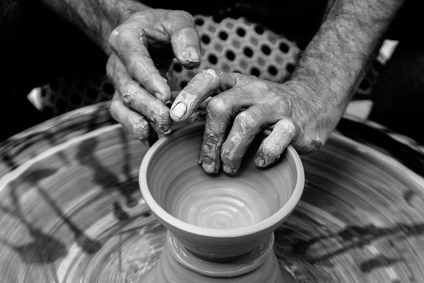 hands spinning pottery to create fair trade home goods