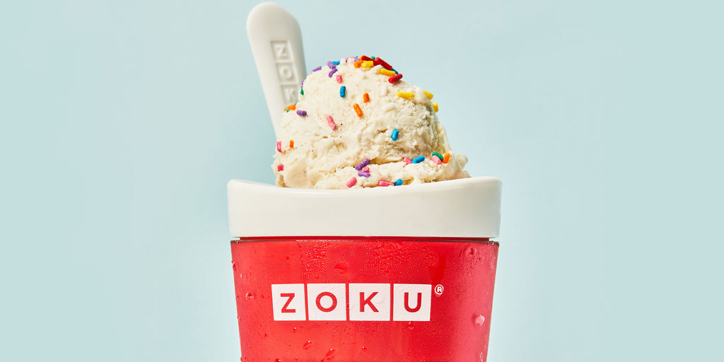 An image of a soda slushy in a ZOKU Slush & Shake Maker topped with vanilla ice cream and sprinkles.