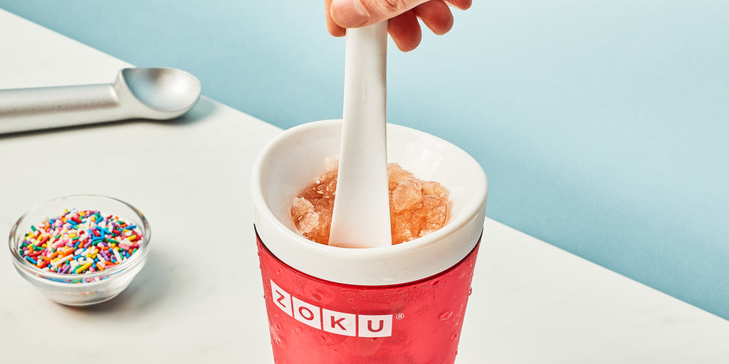 An image of a hand stirring a ZOKU Slush Maker to create a soda slushy.